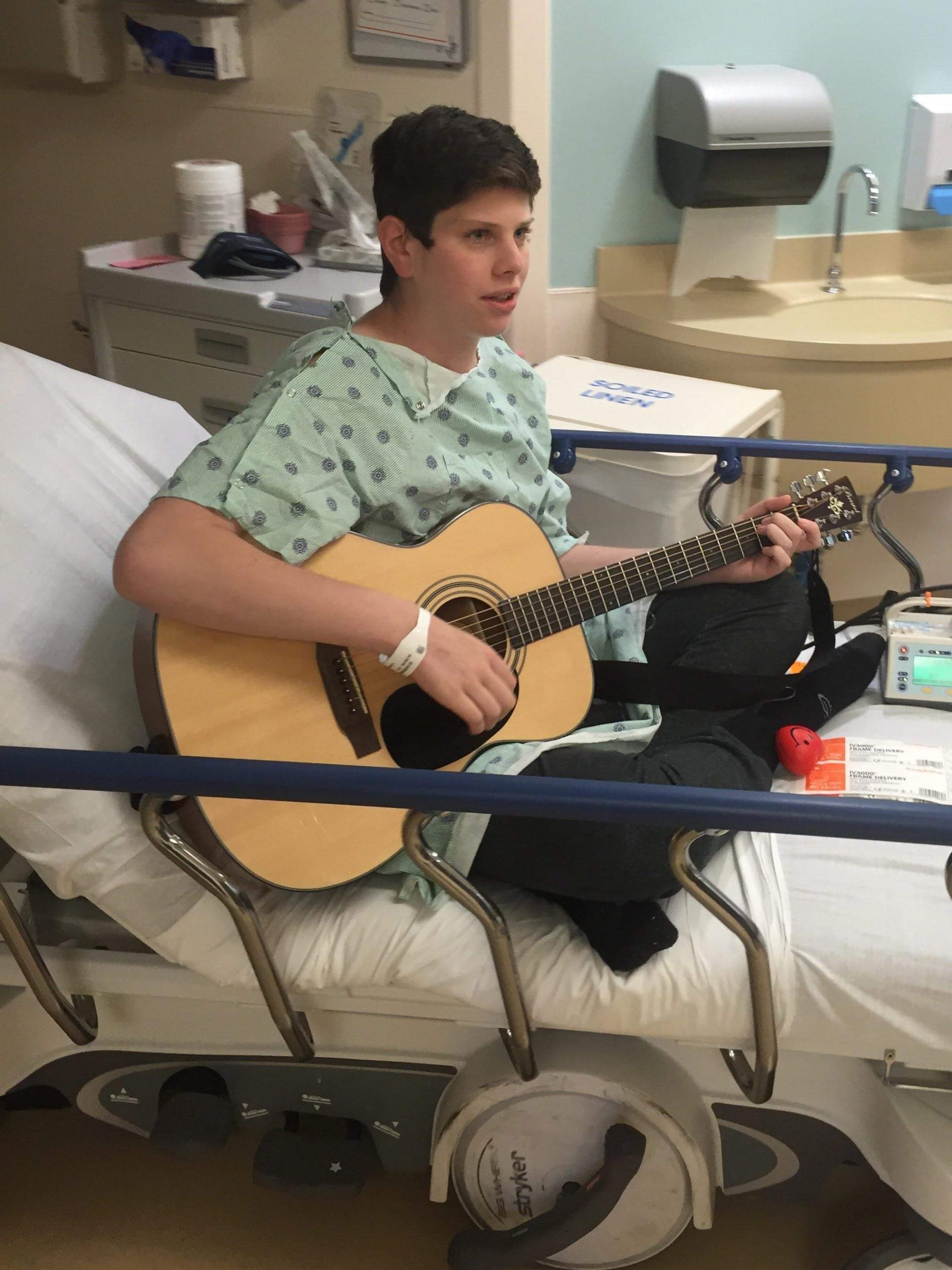 Trevor-Playing-Guitar-in-Hospital-Bed